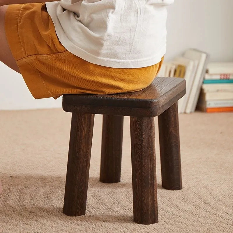 Solid wooden shoes changing stool with a distressed finish and bracket leg structure.