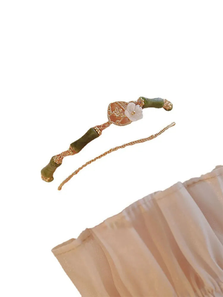 Handmade natural olivine bracelet with double layer design and Bells of Ireland charms on a wrist.