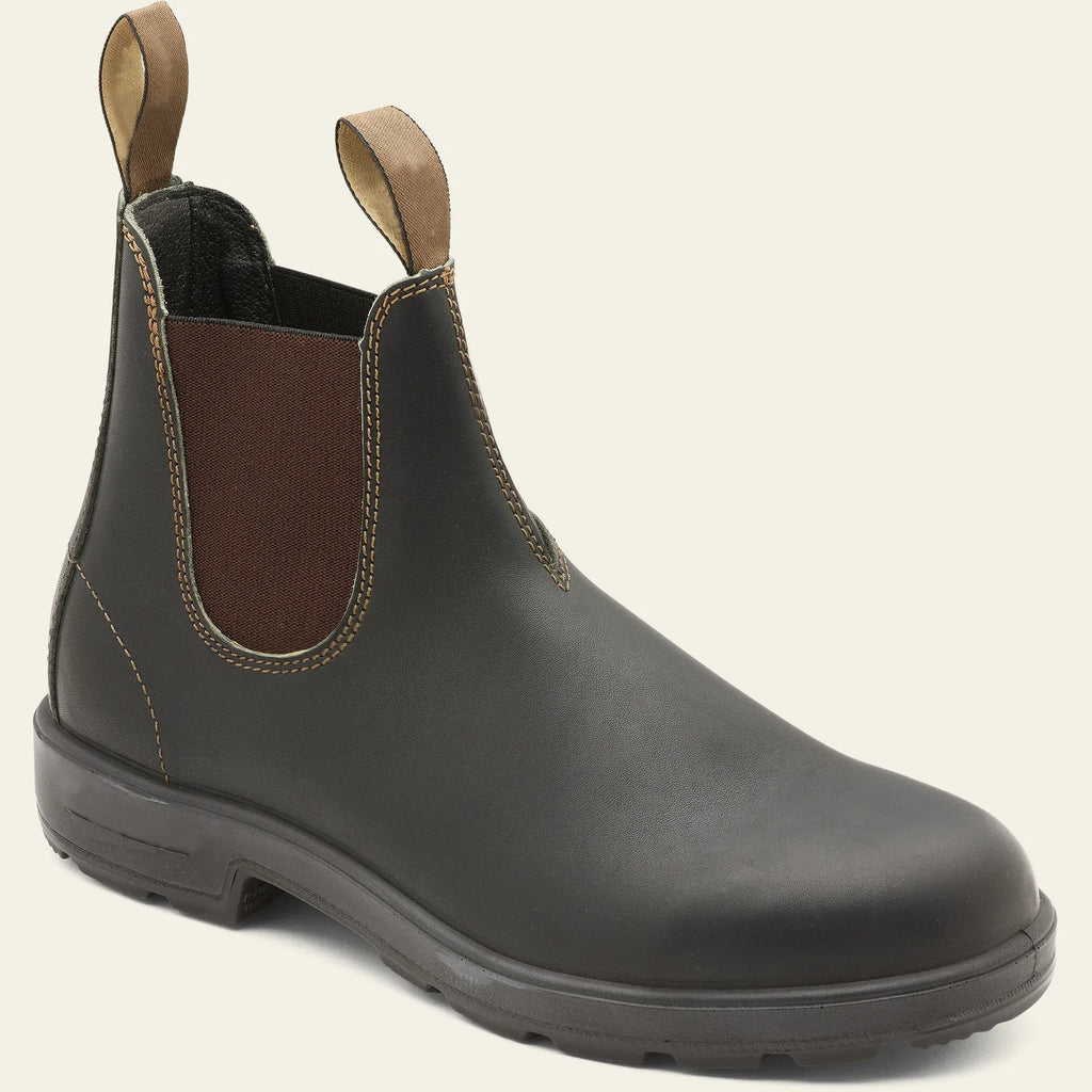Vintage brown Chelsea boots with frosted finish and car suture detailing on a wooden floor.