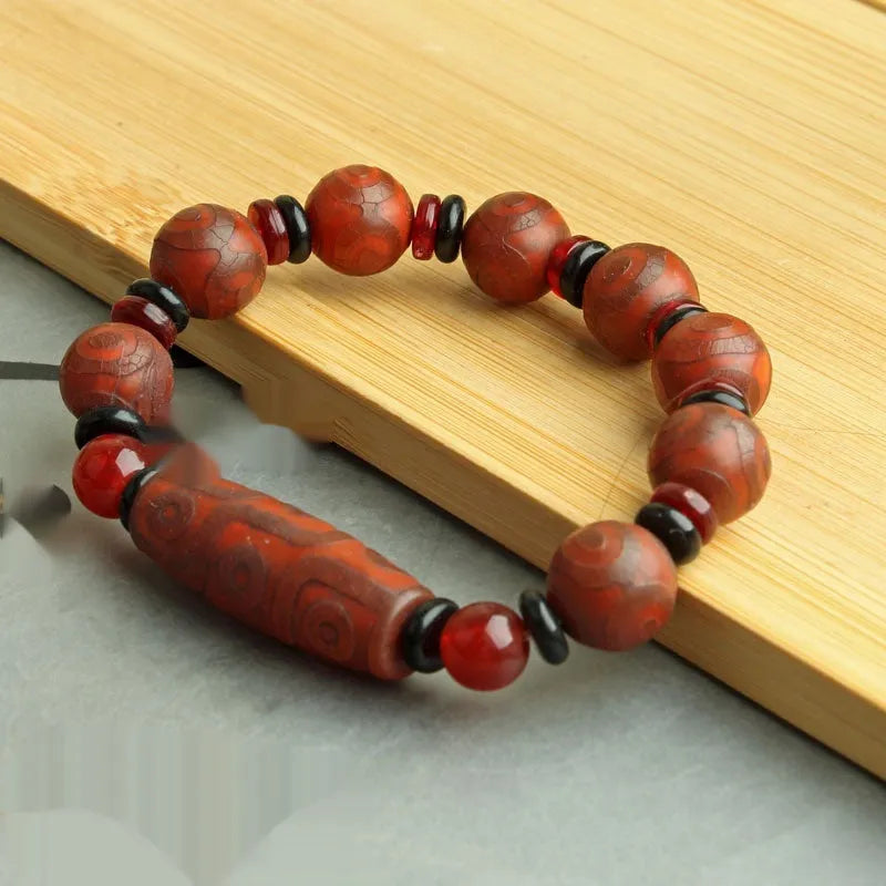 Distressed agate Tibet bead bracelet with three-eye motifs and multiple traditional bead styles on wrist