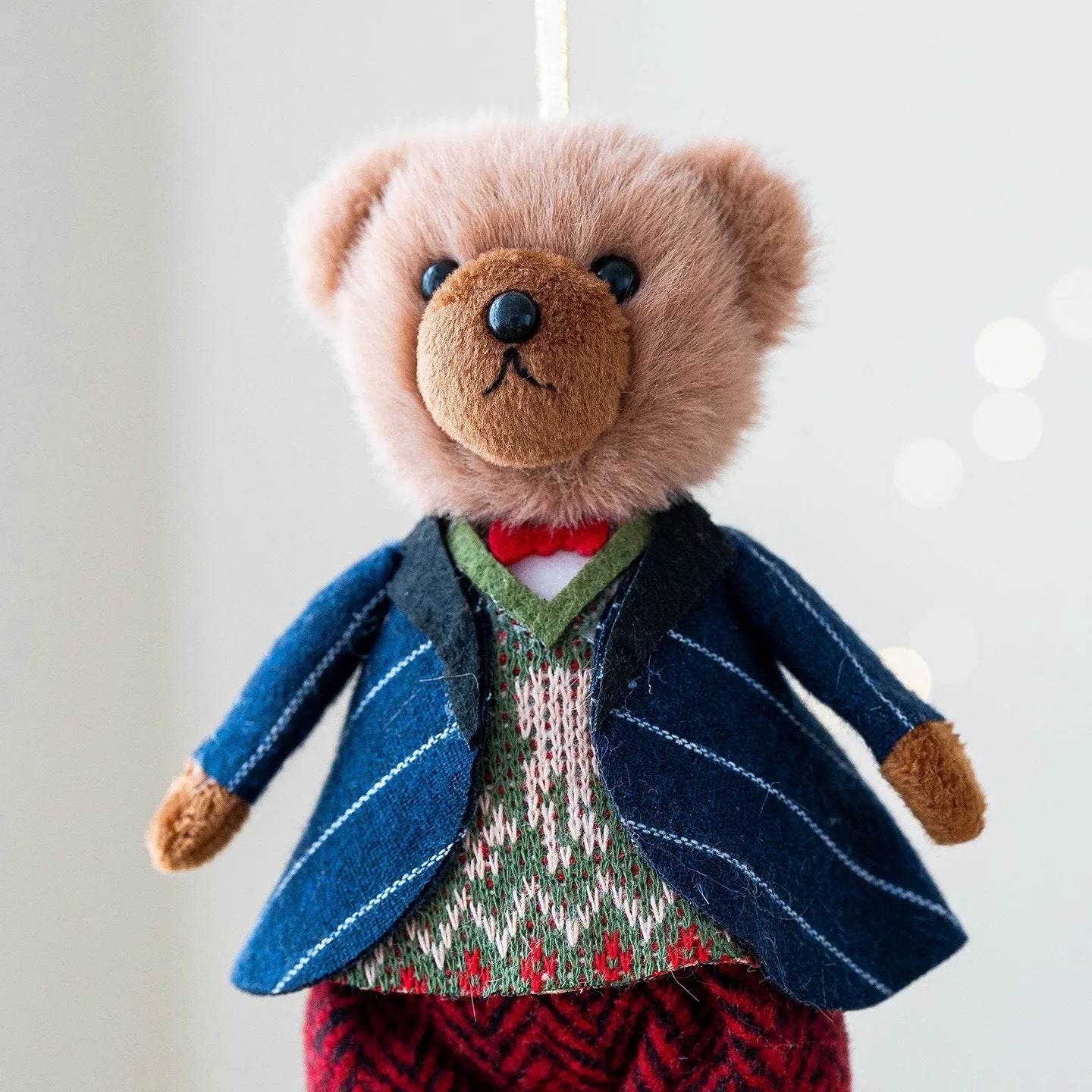 Cartoon plush bear doll wearing a cotton suit with a plaid print, in two colour options.