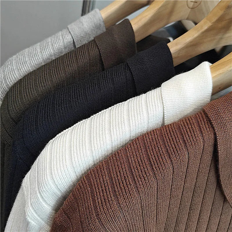 Man wearing a loose fit, textured grey knitted sweater with long sleeves for casual autumn wear.