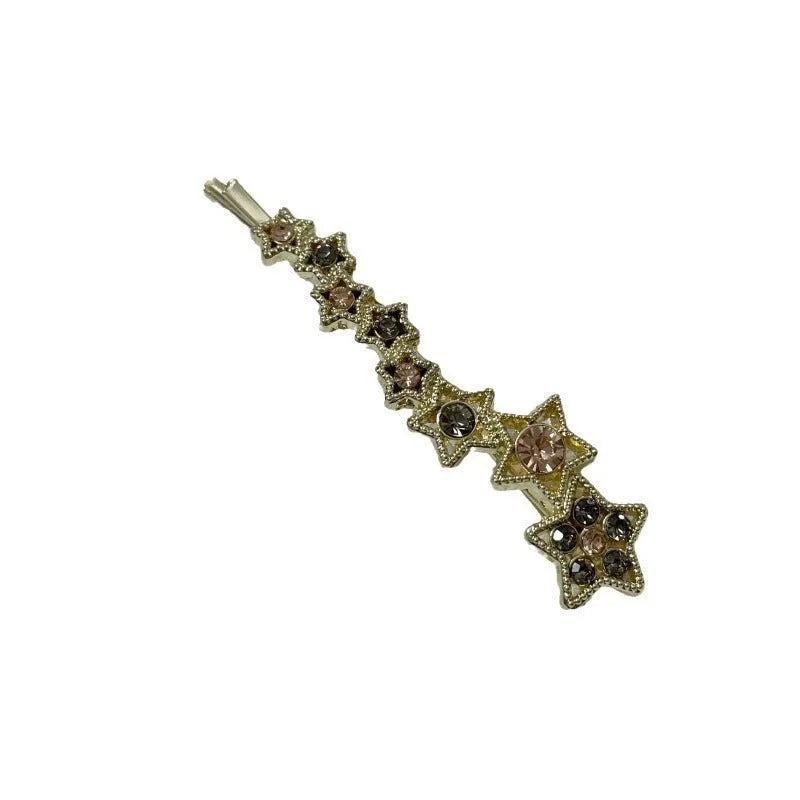 Golden hair clip barrette with a rhinestone five-pointed star, shown on a side angle.