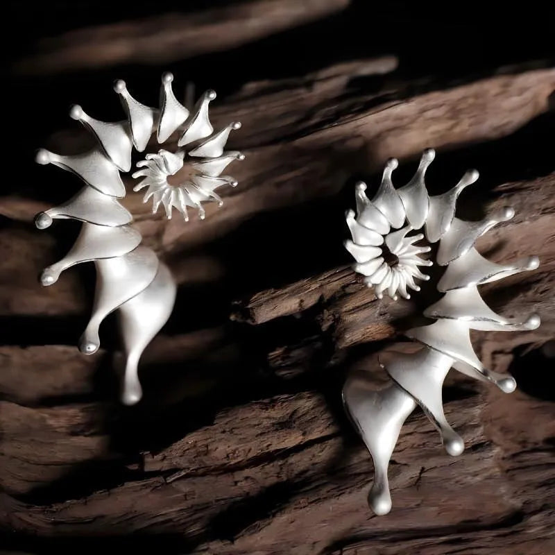 A pair of three-dimensional matte finish conch shell stud earrings in alloy with irregular shaping.