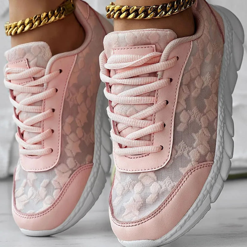 Women's white canvas running shoes with a flat sole and round toe on a neutral background.
