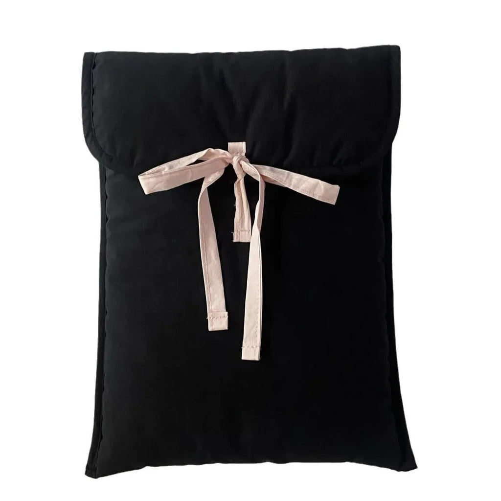 Women's black quilted laptop bag with ballet bow detailing and striped pattern showing laptop compartment