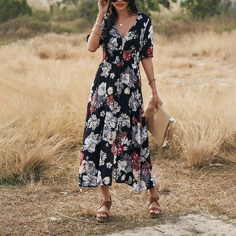 Yellow floral print women's dress with v-neck, short sleeves, elastic high waist, and a large hemline midi skirt.