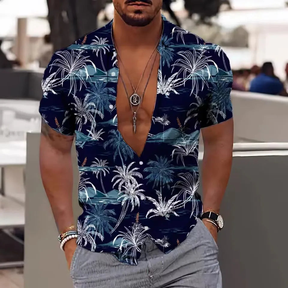 Man wearing a loose floral print short sleeve shirt in a cardigan style on a beach.