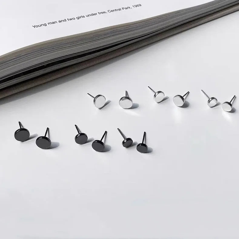 A pair of simple round flat-front sterling silver S999 ear bone stud earrings on a plain background.