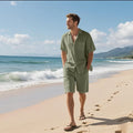 Man wearing a light blue linen blend short sleeve shirt and matching shorts beach set.