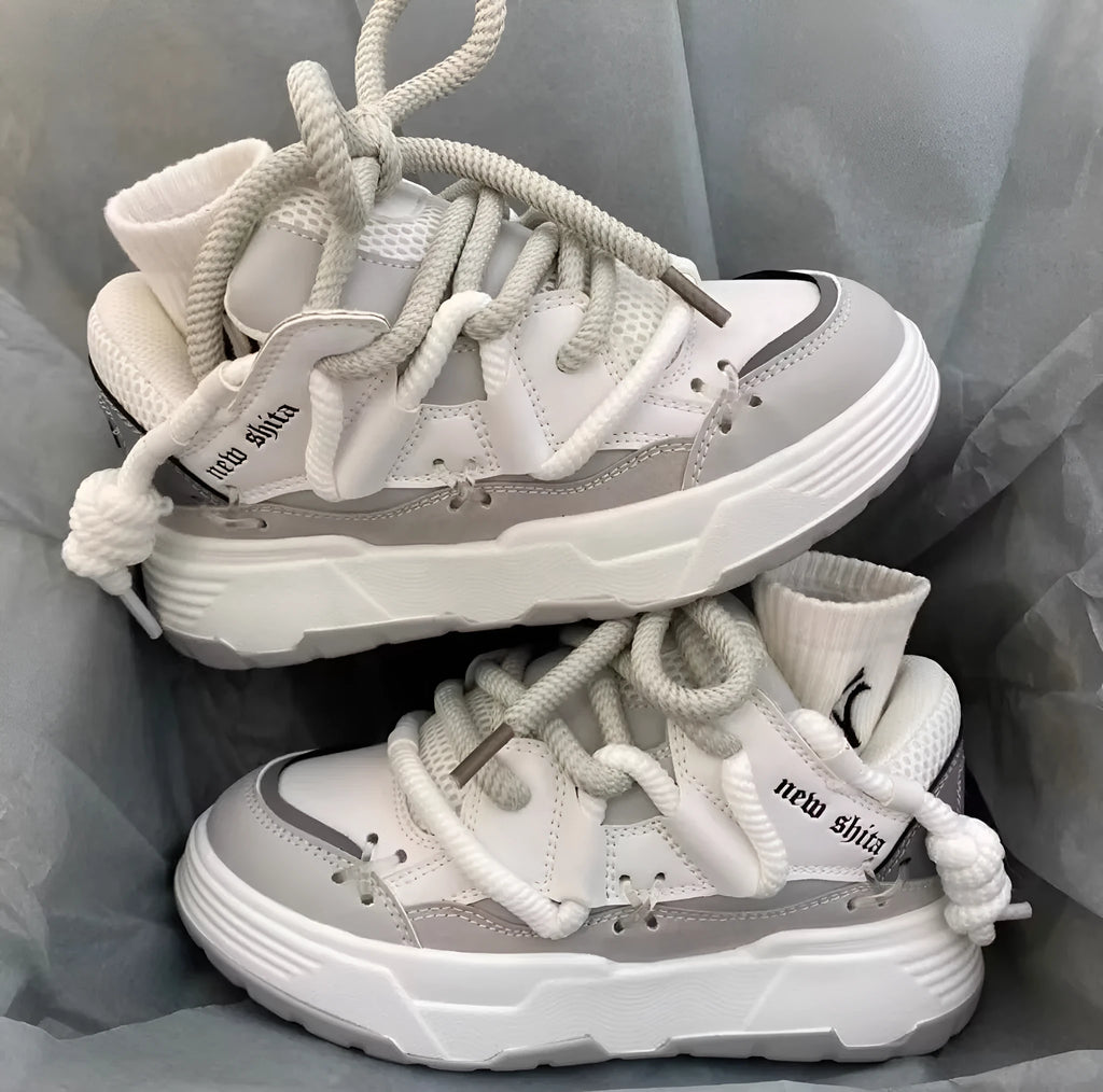 Women's grey retro clunky sneakers with a thick rubber sole and front lace-up closure on a white background.