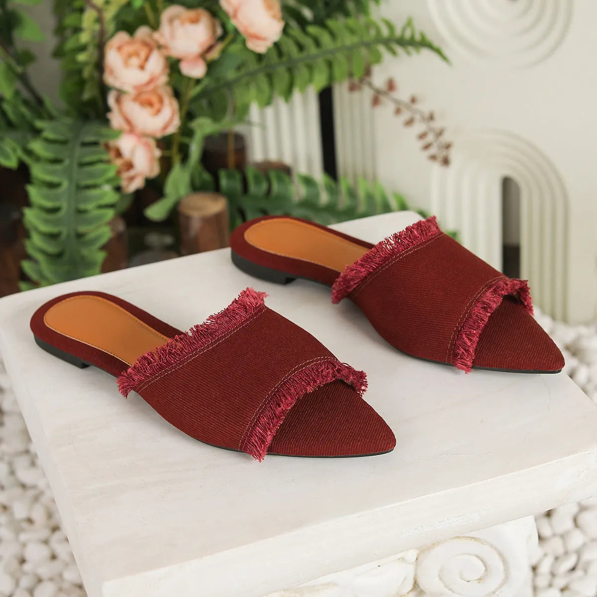 Women's denim flat slippers with a tassel, leather lining, and a lightweight PVC sole.