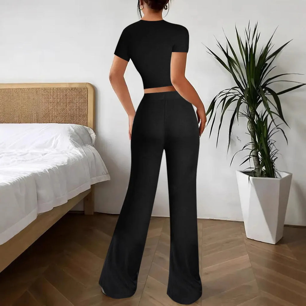 Black women's high waist trousers and short sleeve t-shirt co-ord set on a hanger.
