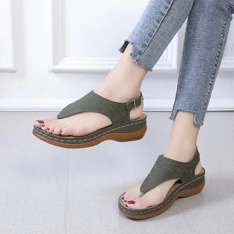 Women's wedge heel flip flop sandals with an adjustable back buckle strap in black.