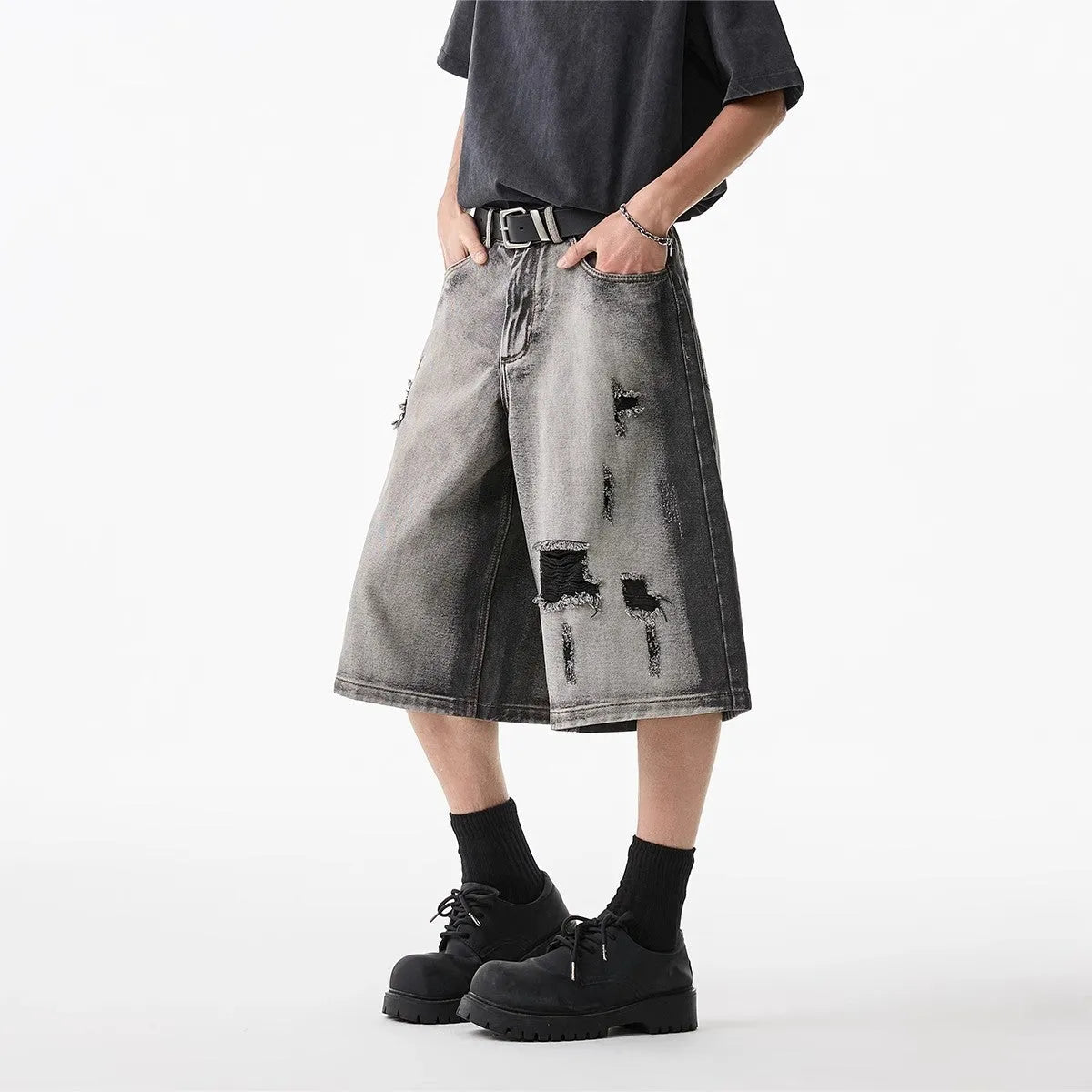 Grey high street washed cotton denim shorts with a loose, cropped fit on a hanger.