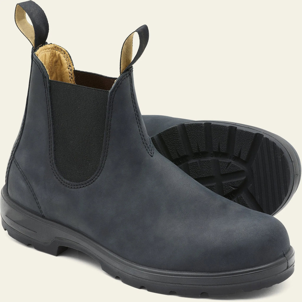Vintage brown Chelsea boots with frosted finish and car suture detailing on a wooden floor.