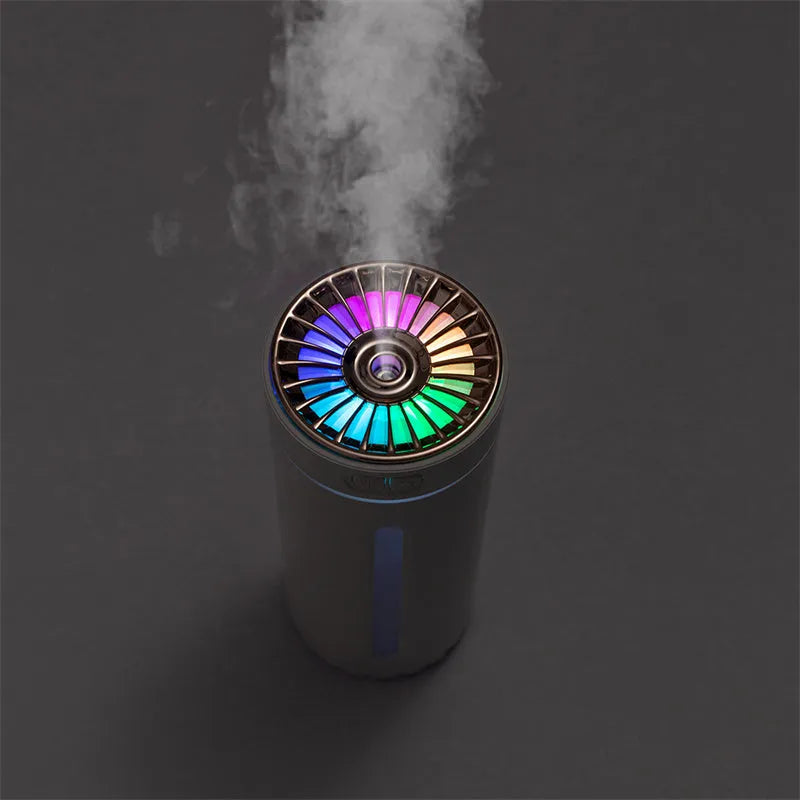 Black portable wireless ultrasonic humidifier with colourful LED lights on a car cup holder.