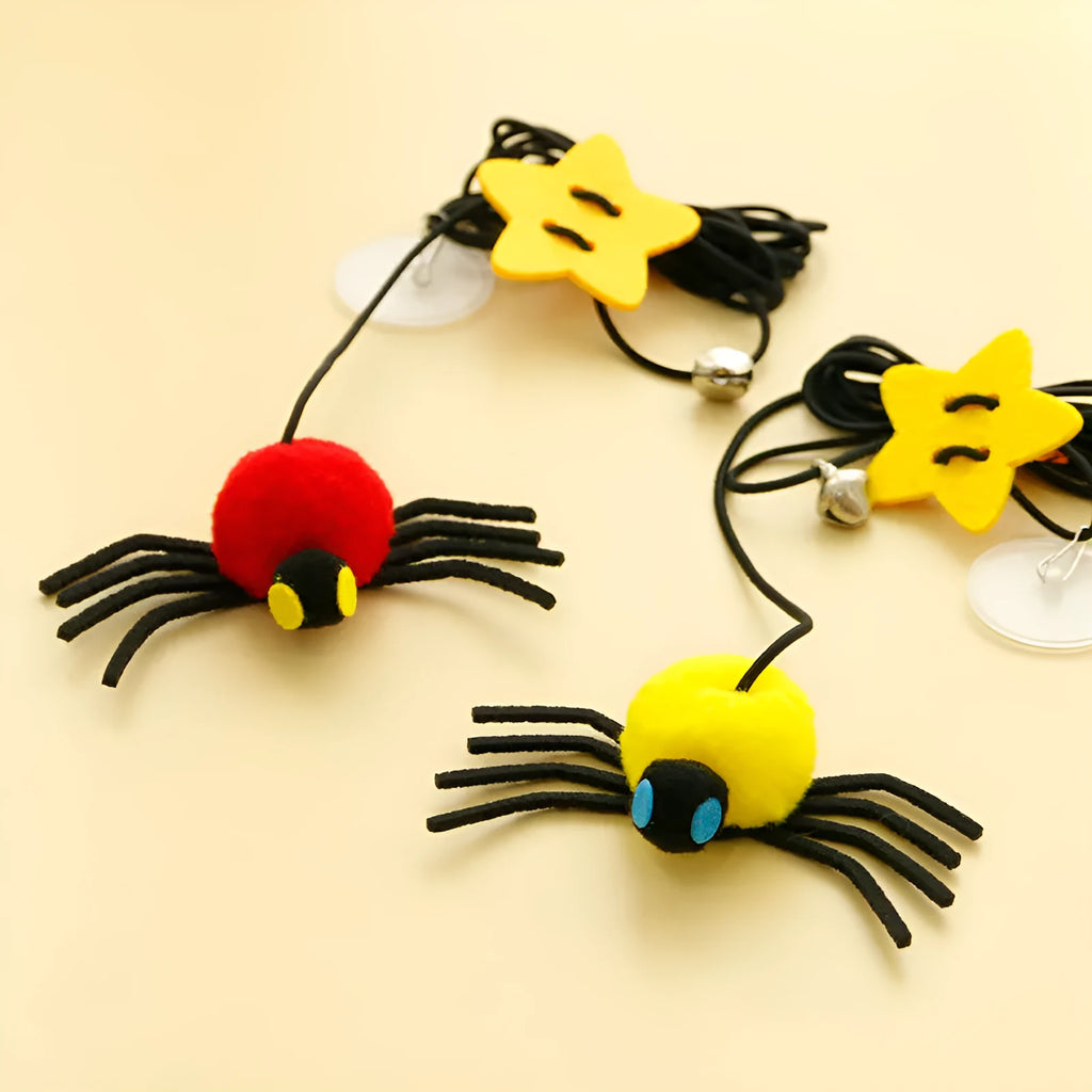 Red and yellow hanging cat toy with elastic rope, feathers, and a bell spider attached to a door.